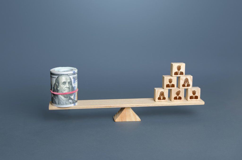 Money dollars and people on scales. Concept of wages for employees and workers.